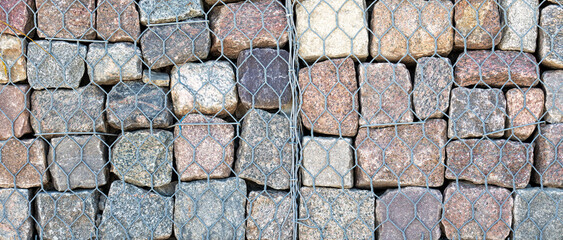 Stone wall, gabion revetment - protection from backshore erosion. Square photo.