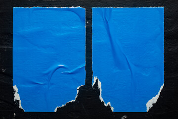 Two blue torn posters on a black background.