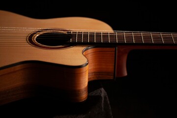 Classical Spanish flamenco guitar close up, dramatically lit isolated on black background with copy...