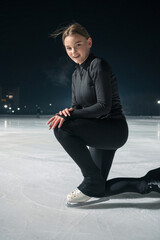 Beautiful young woman ice skating and performing short program