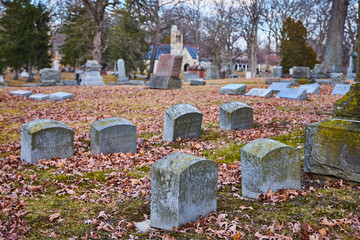 Autumnal Cemetery Scene with Historic Gravestones and Chapel