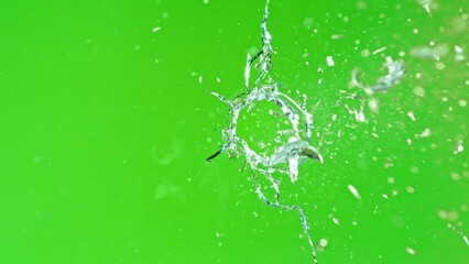 Close-up of gunshot through the glass, shattering against the green background
