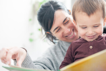 Close-up of the happiness of mother and child reading a book.