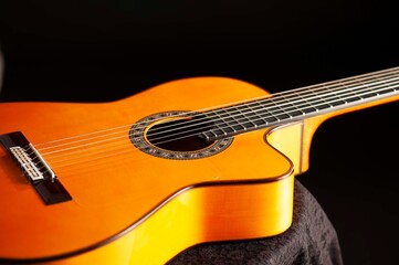 Fototapeta premium Classical Spanish flamenco guitar close up, dramatically lit isolated on black background with copy space.