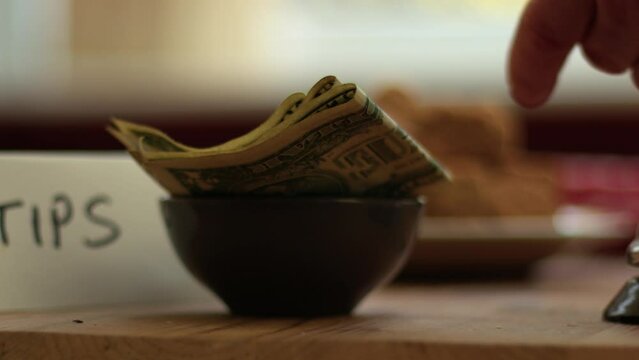Hand leaves tips in cafe bar 