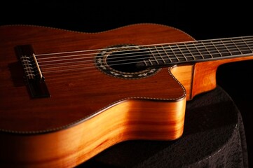 Fototapeta premium Classical Spanish flamenco guitar close up, dramatically lit isolated on black background with copy space.