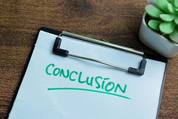 Concept of conclusion write on paperwork isolated on wooden background.