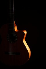 Fototapeta premium Classical Spanish flamenco guitar close up, dramatically lit isolated on black background with copy space.