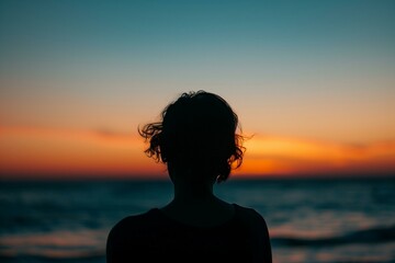 Fototapeta premium Silhouette of Woman Against Ocean Sunset