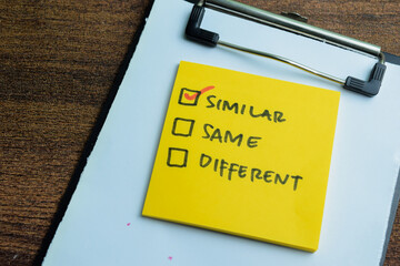 Concept of Similar, Same, Different write on sticky notes isolated on Wooden Table.