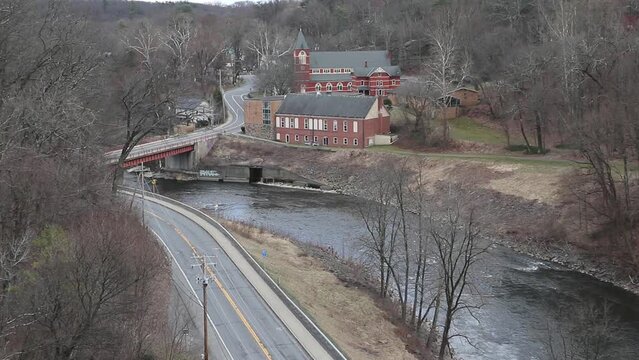 view of church from the rosendale train trestle with cars driving on road below (wallkill valley rail trail, river footage) small town new york state