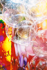 A large number of transparent plastic bubbles floating in the air. The balls are in a colorful red-yellow room, creating a visually attractive and playful atmosphere.