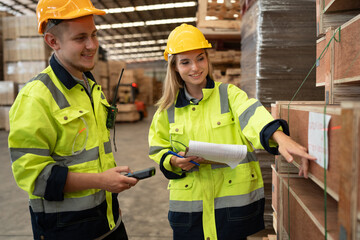 Caucasian businessman and woman checking wood stock with bar code scanner and clipboard at pallets warehouse	 - 763416519
