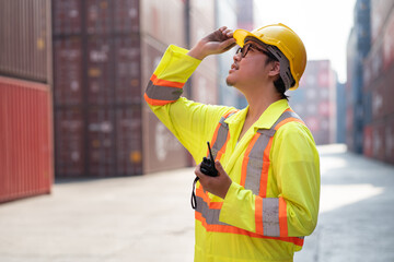 Asia logistic engineer man worker or foreman working with walkie talkie at container site	 - 763416593