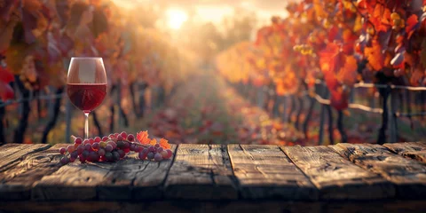 Gordijnen Wood table top with a glass of red wine on blurred vineyard landscape background © Ricardo Costa