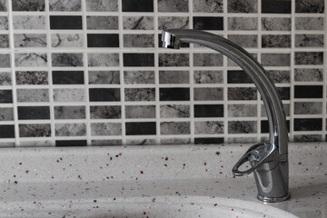 Kitchen Sink and Faucet Against a Ceramic Tiled Background