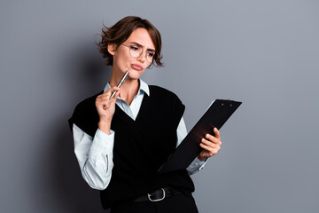 Photo of minded uncertain unsure lady professional realtor hold clipboard pen take notes read contract isolated on gray color background
