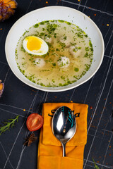 Fresh homemade chicken soup with noodle at table. Black background. Top view. Copy space