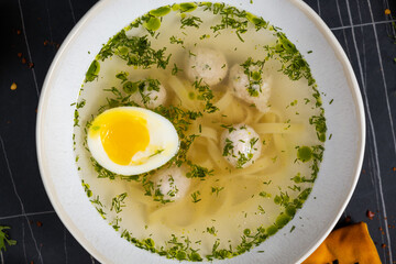 Fresh homemade chicken soup with noodle at table. Black background. Top view. Copy space