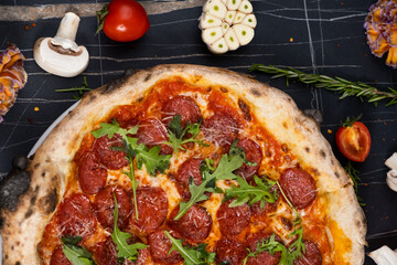 Traditional italian pizza with salami cheese, tomatoes and basil.
