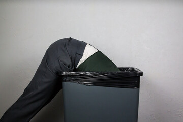 Portrait of Businessman Bent over Trash Can. Concept of Over a Barrel and Stock Market Crash. Head...