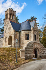 Naklejka premium Historic Stone Church with Bell Tower, Stained Glass - Clear Sky Perspective