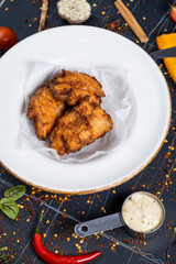 Delicious crispy fried breaded chicken patties with sauce on black background. top view