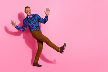 Fototapeta na wymiar Full length photo of funky impressed guy wear striped shirt enjoying disco empty space isolated pink color background