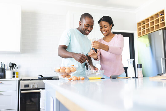 African American couple is preparing a breakfast together in a kitchen with copy space at home