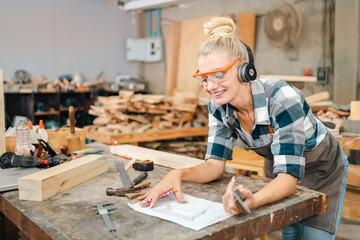 In the carpenter's shop, a professional woman crafts wooden furniture, using tools with skill in her woodwork occupation, showcasing industry prowess.