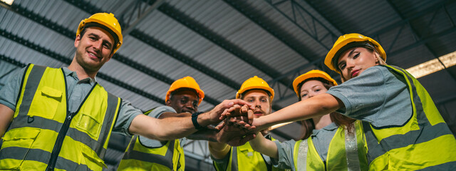 In a factory setting, a team of engineers and foremen emphasize safety and teamwork during a meeting, ensuring success in the construction industry. - 763442585