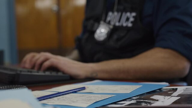 African american typing police officer and paperwork