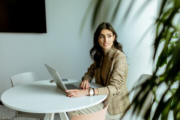 Elegant Professional Woman Working on Her Laptop at a Modern Office Space - 763446365