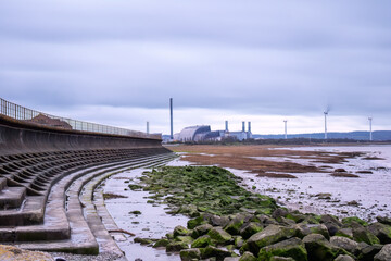severn beach with sea wall and green rocks