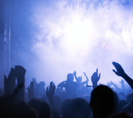 Crowd cheering and watching a band on stage, blurred motion, shallow DOF.