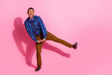 Full length photo of impressed dreamy guy wear striped shirt having disco fun empty space isolated...