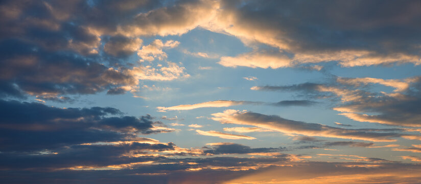 sunset sky horizontal format, lighted fleecy clouds and orange shine