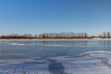 frozen lake covered with snow and ice in winter