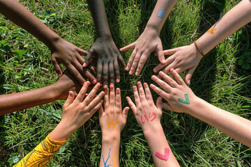 Group of Children With Hands Together Against The Background Of Grass. View From Above. Suitable For Advertising Children's Events, Holidays And Camps