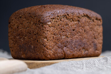 a square dark loaf of bread on the table