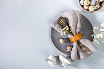 Napkin, vintage cutlery, quail eggs, gray plate, flowers, ceramic bunnies. Gray Easter table setting