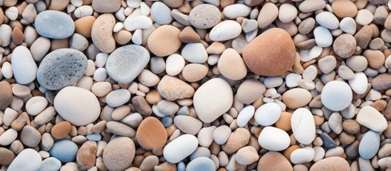 Tuinposter A pile of rocks and gravel on a beach up close © Ilgun