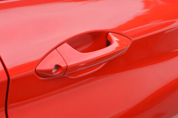 Here's a close-up shot of the sleek, vibrant red car door handle, showcasing its intricate design and modern aesthetic