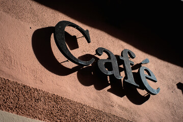 Cafe metal sign with sun shadow