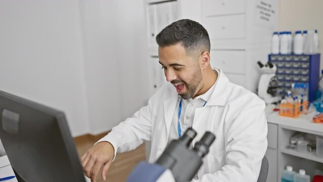Cheerful young hispanic scientist in uniform sparks a 'number one' idea at the lab! computer wizard, happily pointing up, question brewing in his smart mind.