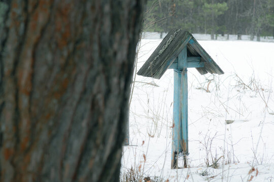 Wooden cross at abandoned cemetery in winter