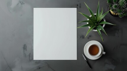 A beautiful workspace with a blank sheet of paper, a cup of tea, a pen, and a potted plant. The...