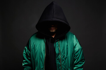 Man in Hood and green bomber jacket. Trendy wear Boy in a hooded sweatshirt - 763474553