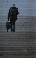 Persona subiendo escaleras de espaldas. Concepto psicología, crecimiento personal - obrazy, fototapety, plakaty
