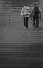 Hombre y mujer subiendo escaleras. Concepto psicología, crecimiento en pareja - obrazy, fototapety, plakaty